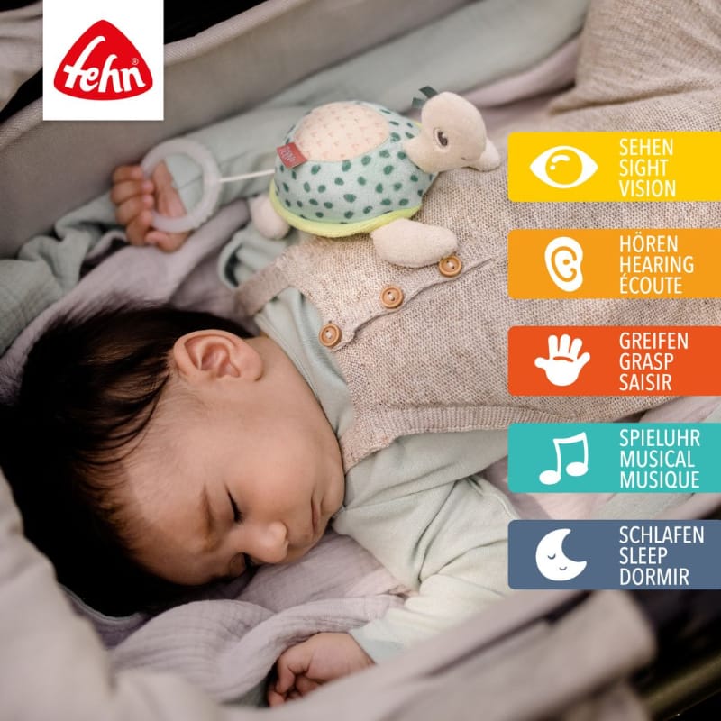 Sleeping baby in pram with Fehn Mini Musical Turtle resting on chest — supports sight, hearing, grasping, music and sleep development from 0+ months