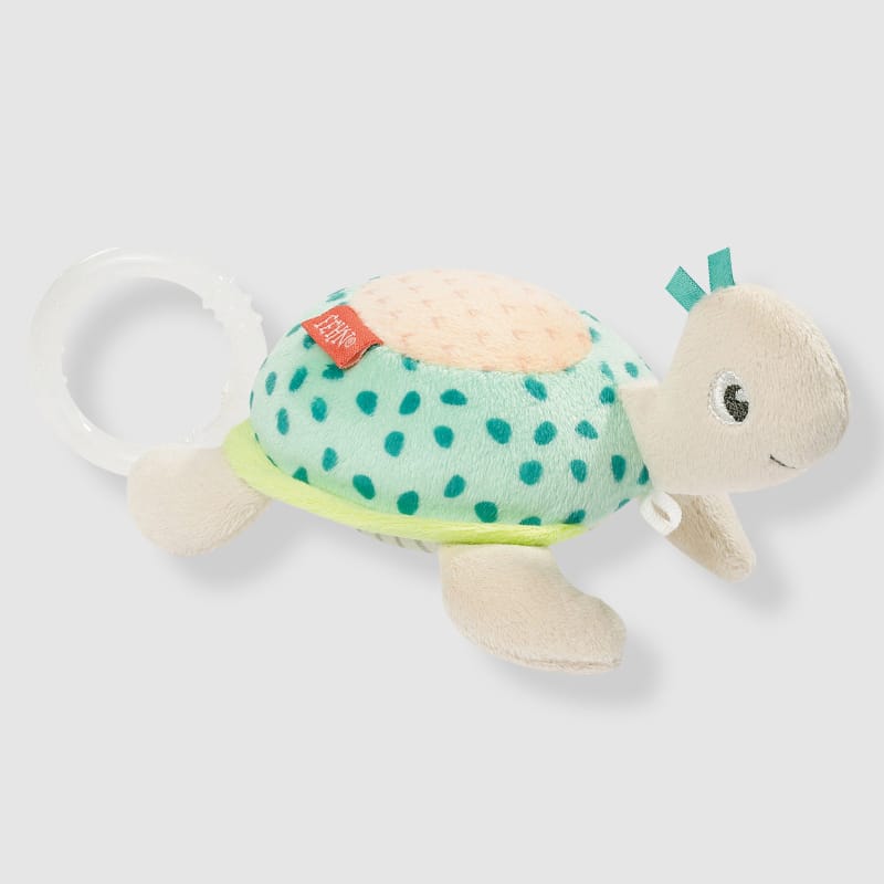 Fehn Mini Musical Turtle on grey background — cream plush turtle with teal spotted shell, yellow-green trim, teal ribbon tags and white grasping ring