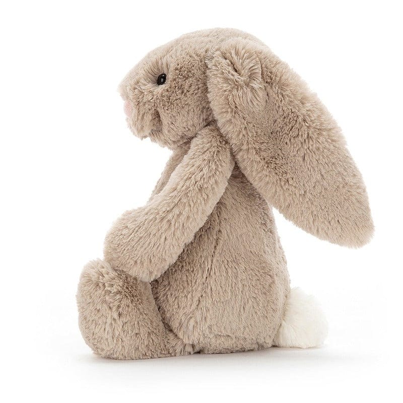 Jellycat Bashful Beige Bunny Medium side view — soft beige plush bunny with long floppy ears draped forward, fluffy textured fur with golden highlights and small white round tail, sitting profile