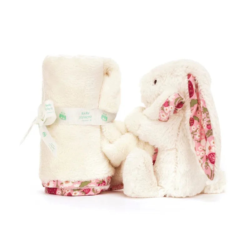 Jellycat Blossom Cream Bunny Berry Soother gift set — rolled blanket tied with Baby Jellycat ribbon alongside matching cream bunny with long strawberry floral ears