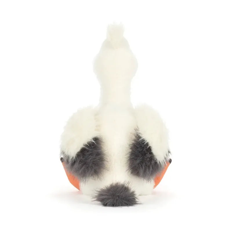 Jellycat Keli Pelican angled back view — white plush pelican with black and white layered wing feathers and orange webbed feet