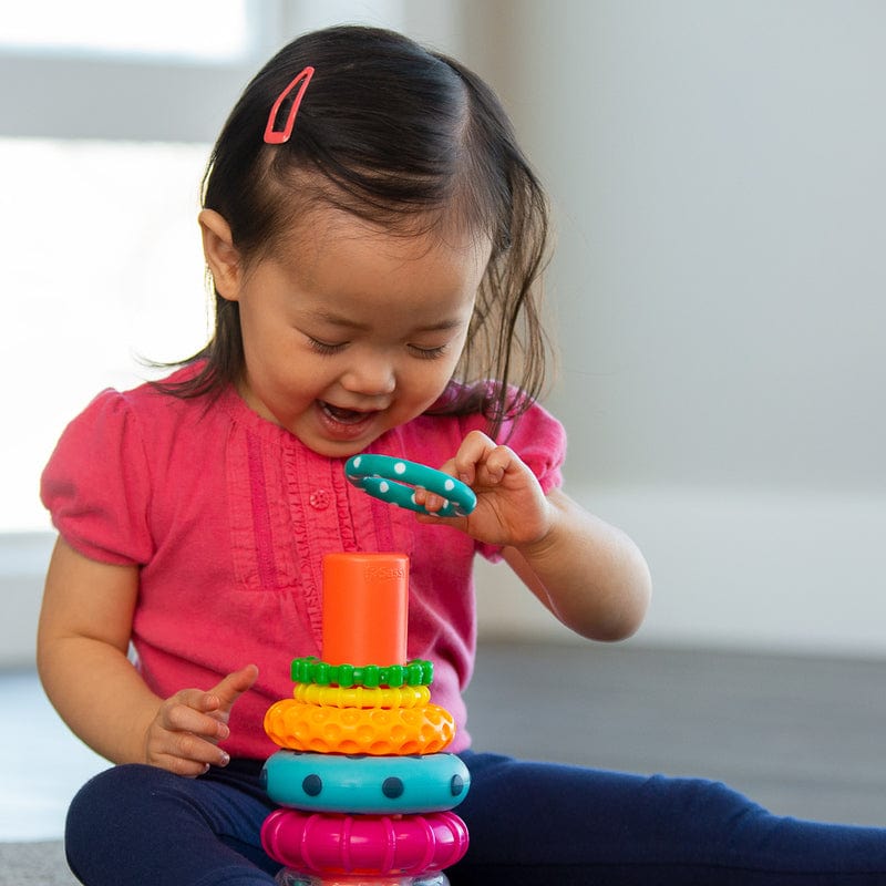 Young child placing a ring on the Sassy Baby stacking toy