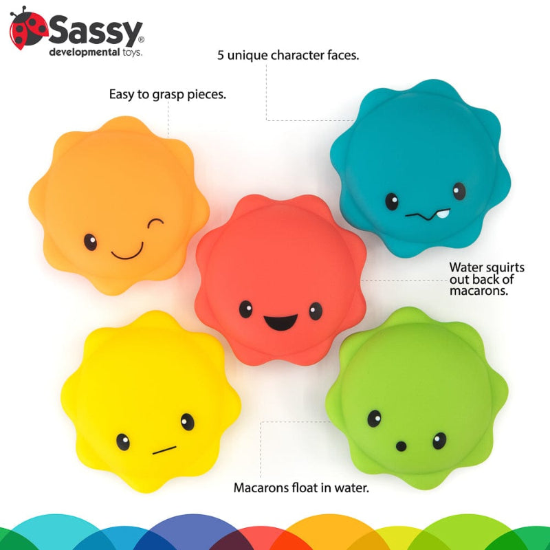 Five colourful, smiling macaron-shaped bath squirters on a white background.